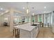 Spacious kitchen with a central island and stainless steel sink, flowing into a dining area and living room at 141 Compass Rd, Hampton, GA 30228