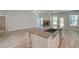Stylish kitchen island with a sink and stainless steel appliances, overlooking an inviting living room with fireplace at 141 Compass Rd, Hampton, GA 30228
