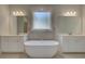 Relaxing main bathroom with a soaking tub, dual vanities, and elegant fixtures, perfect for unwinding at 141 Compass Rd, Hampton, GA 30228