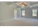 Expansive main bedroom featuring a tray ceiling, neutral walls, and abundant natural light from large windows at 141 Compass Rd, Hampton, GA 30228