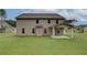 Backyard view of home's exterior with a covered patio and green lawn at 145 Compass Rd, Hampton, GA 30228