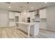 Spacious kitchen features a large island with pendant lights and stainless steel appliances at 145 Compass Rd, Hampton, GA 30228