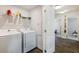 Bright laundry room with washer, dryer, wire shelving, and modern flooring at 319 Hayden Cir, Woodstock, GA 30189