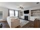 Bright living room featuring a fireplace, built-in shelving, ceiling fan, and hardwood floors at 319 Hayden Cir, Woodstock, GA 30189