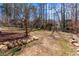 Large backyard with a mix of grassy areas, mulch, and decorative stone edging at 3850 Pilgrim Mill Rd, Cumming, GA 30041