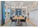 Formal dining room featuring custom blue wallpaper, large windows, and a modern light fixture over a wood table at 137 Compass Rd, Hampton, GA 30228