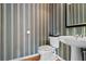 Charming powder room with a pedestal sink and unique striped wallpaper at 325 Stonecastle Pass, South Fulton, GA 30331