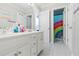 Bright bathroom featuring double sinks, white cabinetry, and a rainbow shower curtain at 325 Stonecastle Pass, South Fulton, GA 30331