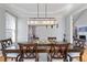 Dining room with modern light fixture, hardwood floors, and access to the kitchen at 325 Stonecastle Pass, South Fulton, GA 30331