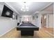 Spacious game room with a pool table, large TV, and hardwood flooring, great for entertainment at 325 Stonecastle Pass, South Fulton, GA 30331