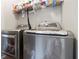 Laundry room features side by side washer and dryer with wire shelving at 325 Stonecastle Pass, South Fulton, GA 30331