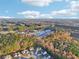 An aerial view of homes and commercial buildings surrounded by lush, colorful trees at 382 Daffodil Dr, Temple, GA 30179