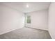 A simple, carpeted bedroom features neutral walls and a bright window, providing a quiet space at 382 Daffodil Dr, Temple, GA 30179