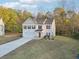Charming two-story home with a well-manicured lawn and a long driveway, surrounded by lush trees at 382 Daffodil Dr, Temple, GA 30179