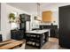 Modern kitchen with black cabinetry, contrasting white countertops, and stainless steel appliances at 11572 Serenbe Ln, Chattahoochee Hills, GA 30268