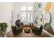 Living room with unique wall art, two armchairs, hardwood floors, a modern rug, and lots of natural light at 11572 Serenbe Ln, Chattahoochee Hills, GA 30268