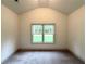 Bedroom featuring neutral carpet, a vaulted ceiling, and a large window at 121 Honey Creek Rd, Conyers, GA 30094