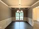 Elegant dining room featuring wainscoting, a decorative chandelier, and a large window at 121 Honey Creek Rd, Conyers, GA 30094