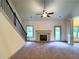 Cozy living room with a fireplace, ceiling fan, neutral carpet, and access to the backyard at 121 Honey Creek Rd, Conyers, GA 30094