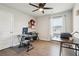 Well-lit bedroom features wood flooring, a ceiling fan, a desk, and a bright window at 201 Cranapple Ln, Mcdonough, GA 30253