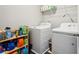 Functional laundry room features a washer and dryer, along with shelving for organized storage of supplies at 201 Cranapple Ln, Mcdonough, GA 30253