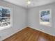 Sunlit bedroom featuring hardwood floors and two large windows overlooking greenery at 233 Bay Creek Rd, Loganville, GA 30052