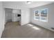 Bright living room with large windows and neutral carpet adjacent to a kitchen at 233 Bay Creek Rd, Loganville, GA 30052