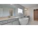 Bathroom featuring a freestanding tub, double vanity with white countertops, and marble flooring at 400 Hatcher Ct, Hampton, GA 30228