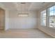 Bright dining room with hardwood floors, modern lighting fixture, large windows and wainscotting at 400 Hatcher Ct, Hampton, GA 30228