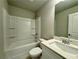 Modern bathroom with tub-shower combo, sleek vanity with quartz countertop, and ample lighting fixtures at 123 Honey Creek Rd, Conyers, GA 30094