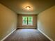 A carpeted bedroom featuring a window with natural light and neutral wall colors, enhancing the room's cozy feel at 123 Honey Creek Rd, Conyers, GA 30094