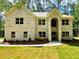 Charming, light brick two-story home featuring a manicured lawn and a welcoming, arched entryway at 123 Honey Creek Rd, Conyers, GA 30094