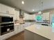 Bright kitchen with stainless steel appliances, an island and pendant lights over the quartz countertop at 123 Honey Creek Rd, Conyers, GA 30094