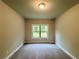 Cozy room with neutral carpet and paint, with a large window view to the outside at 123 Honey Creek Rd, Conyers, GA 30094