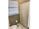 Bathroom includes toilet, shower with curtain, and a window for natural light at 2179 Powers Ferry Dr, Marietta, GA 30067