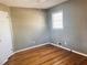 Neutral-toned bedroom featuring hardwood floors and a window for natural light at 2179 Powers Ferry Dr, Marietta, GA 30067