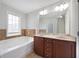 Bathroom featuring a double vanity sink, and a soaking tub under a window at 2308 Oakton Se Pl, Smyrna, GA 30082