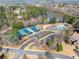 Aerial view of community pool and tennis courts, surrounded by trees and lake at 3070 Corsair Curv, Cumming, GA 30040