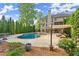 Luxurious backyard with a large pool, spa, outdoor seating, and mature landscaping at 3070 Corsair Curv, Cumming, GA 30040