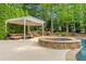 Backyard with in-ground pool, hot tub, pergola over sitting area, fire pit, and swing set at 3070 Corsair Curv, Cumming, GA 30040