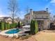 Back of house and luxury pool with water feature, cabana, manicured lawn, and mature trees at 3070 Corsair Curv, Cumming, GA 30040