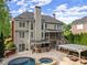 Stunning backyard with outdoor kitchen, pergola and lush landscaping; in-ground pool, hot tub at 3070 Corsair Curv, Cumming, GA 30040
