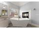 Bright bathroom with a modern soaking tub and fireplace, window bringing in natural light at 3070 Corsair Curv, Cumming, GA 30040