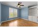 Bedroom with blue walls, hardwood floors, and a built-in bookcase at 3070 Corsair Curv, Cumming, GA 30040