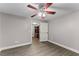 Bedroom with wood flooring, ceiling fan, and a view into adjacent closet with custom shelving at 3070 Corsair Curv, Cumming, GA 30040