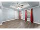 Bedroom boasts wood floors, recessed ceilings, and a large window with red privacy curtains at 3070 Corsair Curv, Cumming, GA 30040