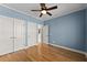 Bright bedroom featuring hardwood floors, closet, and white trim at 3070 Corsair Curv, Cumming, GA 30040