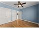 Bedroom features blue walls, hardwood floors, and ample closet space at 3070 Corsair Curv, Cumming, GA 30040