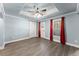 Bedroom with wood-look flooring, ceiling fan, and stylish red curtains for natural light control at 3070 Corsair Curv, Cumming, GA 30040