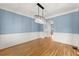 Dining room featuring wainscoting, hardwood floors, and a modern chandelier at 3070 Corsair Curv, Cumming, GA 30040